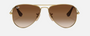 Ray-Ban Junior Aviator Kids RJ9506S 223/13 pilot sunglasses for kids in full rim metal, with polished arista gold frame, and brown lenses. 52mm in lens size, 14mm in bridge size, and 125mm in temple length.