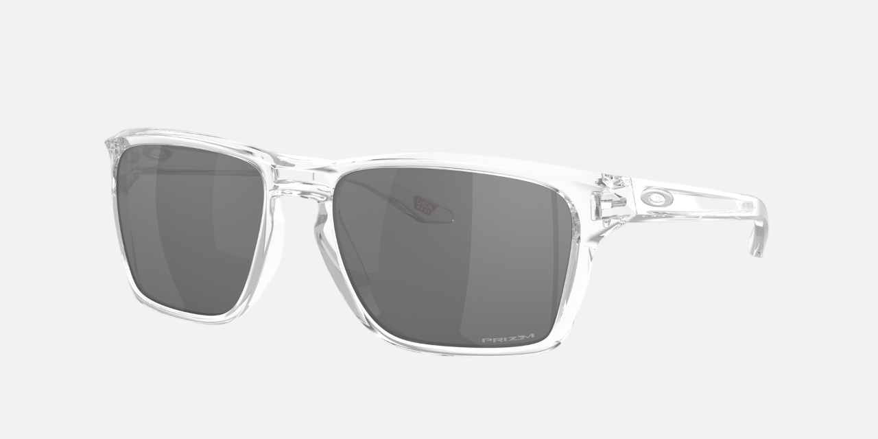 Oakley Sylas 29 rectangular sunglasses for men in full rim plastic, with transparent frame, and black lenses. 57mm in lens size, 17mm in bridge size, and 142mm in temple length.