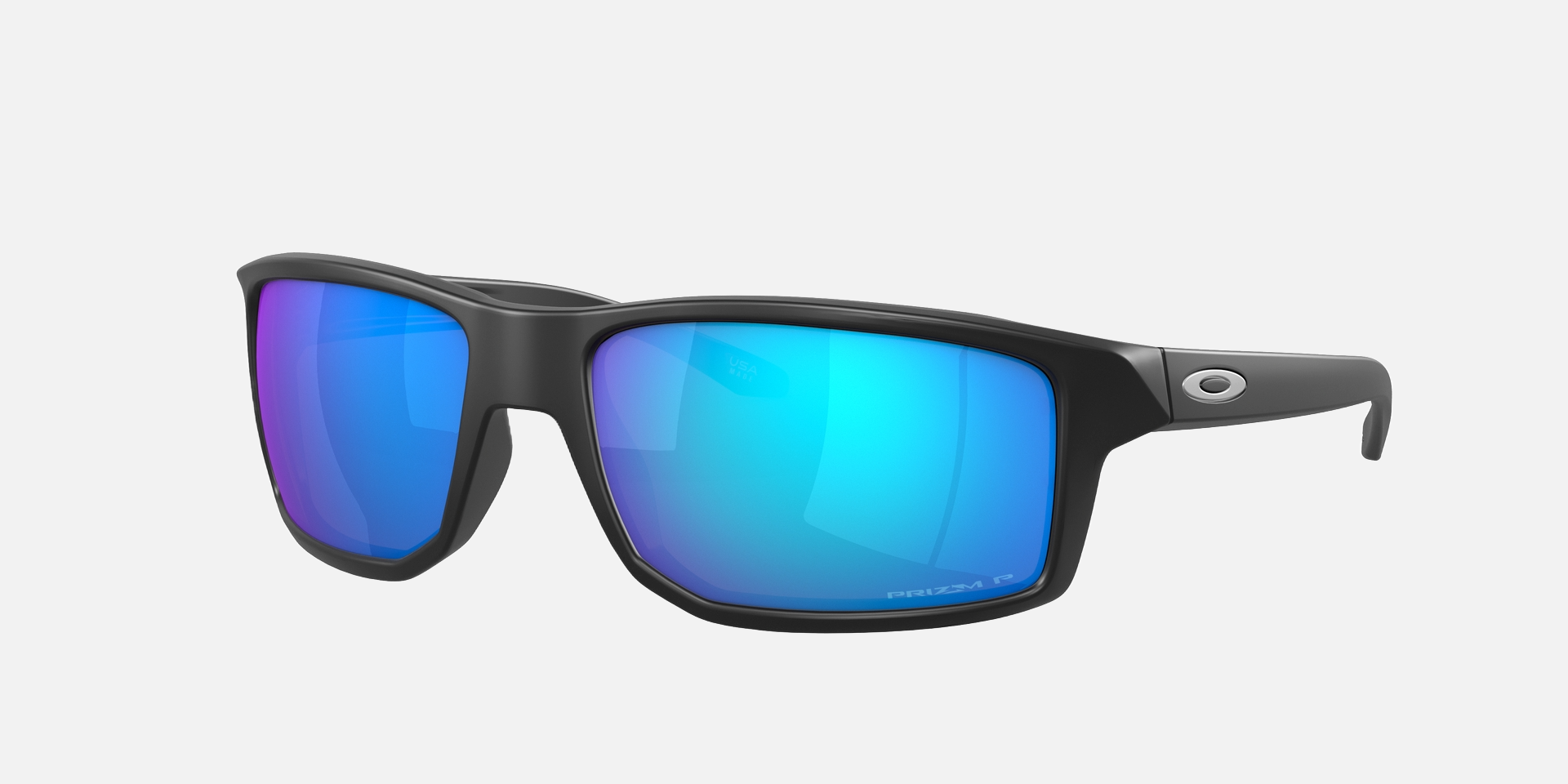 Oakley Gibston 12 rectangular sunglasses for men in full rim plastic, with black frame, and blue lenses. 60mm in lens size, 17mm in bridge size, and 132mm in temple length.