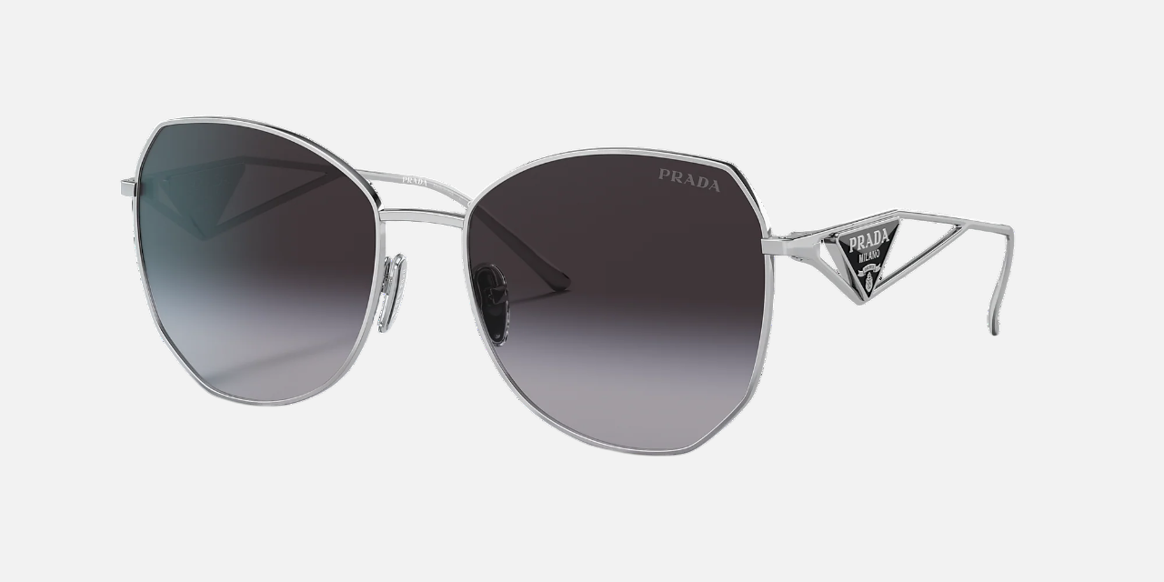 Prada PR 57YS 1BC5D1 irregular sunglasses for women in full rim metal, with silver frame, and grey gradient lenses. 57mm in lens size, 18mm in bridge size, and 140mm in temple length.