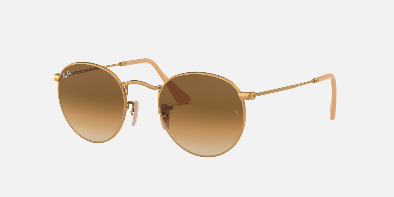 Ray-Ban Round Metal RB3447 RB3447 112/51 round sunglasses for unisex in full rim metal, with matte gold frame, and light brown gradient lenses. 50mm in lens size, 21mm in bridge size, and 145mm in temple length.
