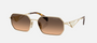 Prada PR A51S ZVN50C irregular sunglasses for women in full rim metal, with pale gold frame, and brown with grey gradient lenses. 58mm in lens size, 17mm in bridge size, and 140mm in temple length.