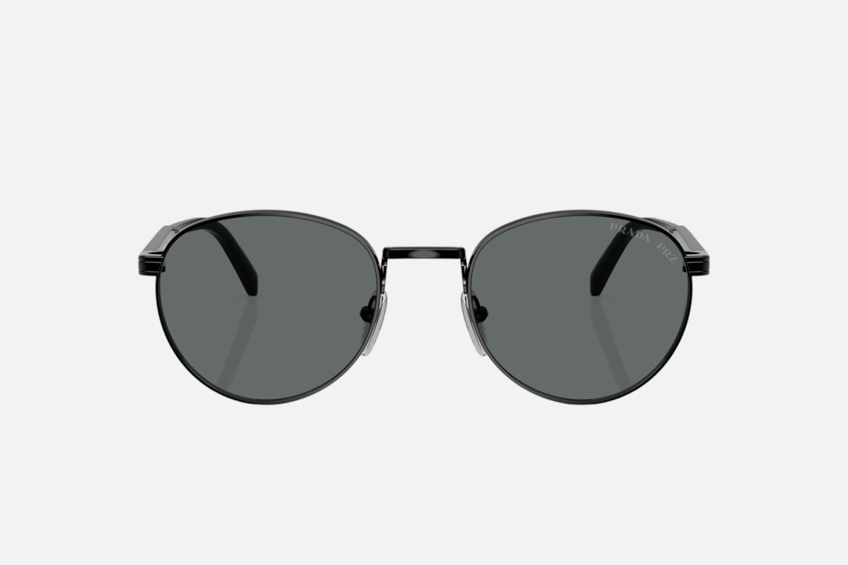 Prada PR B51S 1AB5Z1 oval sunglasses for men in full rim metal, with glossy black frame, and black lenses. 53mm in lens size, 21mm in bridge size, and 145mm in temple length.