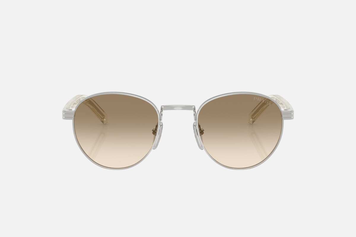 Prada PR B52S 1BC80K round sunglasses for women in full rim steel, with silver frame, and light yellow with brown lenses. 49mm in lens size, 21mm in bridge size, and 145mm in temple length.