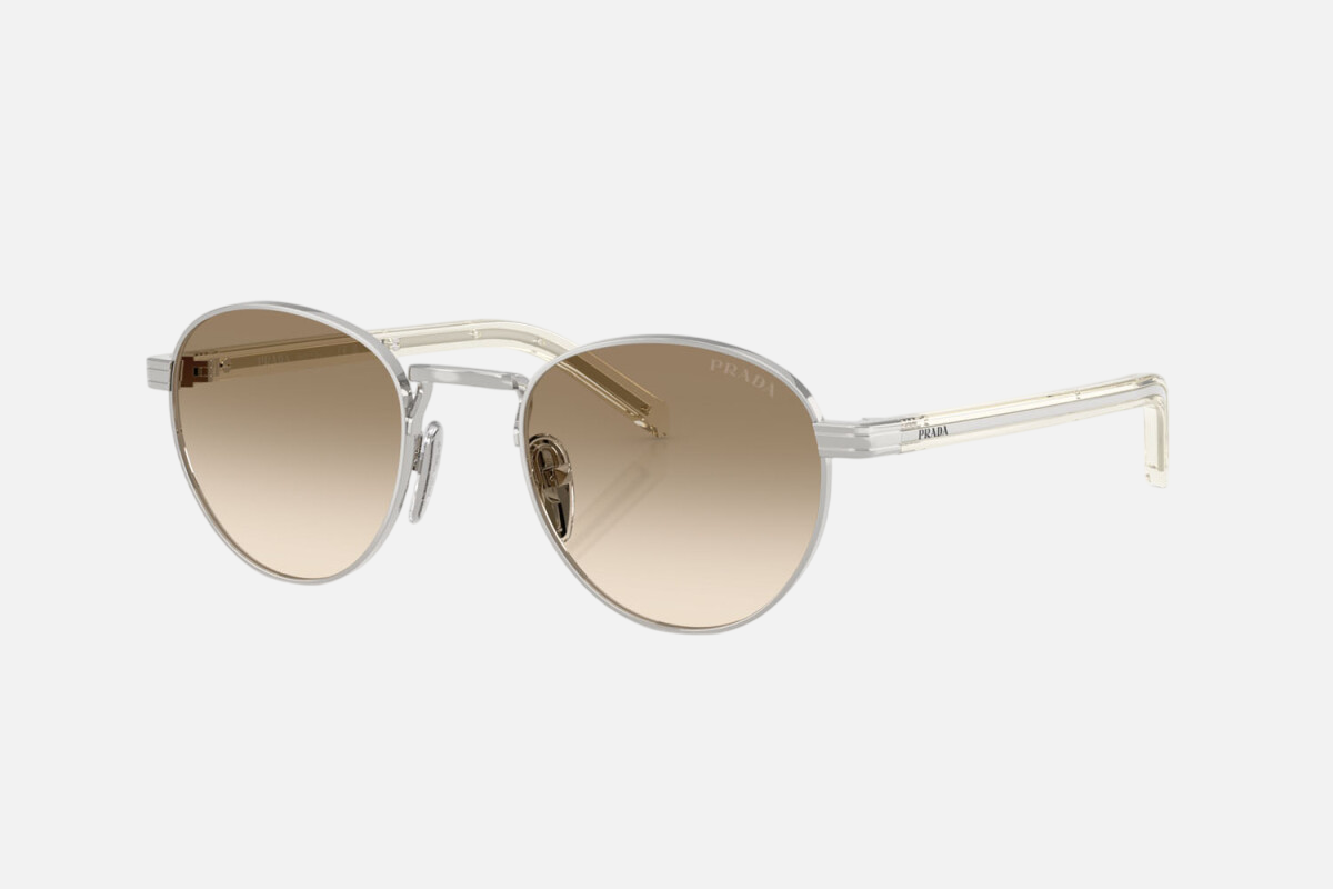 Prada PR B52S 1BC80K round sunglasses for women in full rim steel, with silver frame, and light yellow with brown lenses. 49mm in lens size, 21mm in bridge size, and 145mm in temple length.