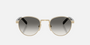 Prada PR B52S ZVN02C round sunglasses for women in full rim steel, with pale gold frame, and grey gradient lenses. 49mm in lens size, 21mm in bridge size, and 145mm in temple length.