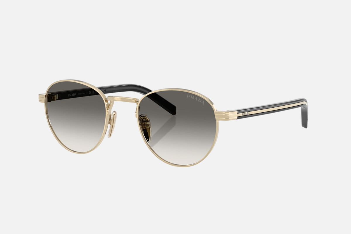 Prada PR B52S ZVN02C round sunglasses for women in full rim steel, with pale gold frame, and grey gradient lenses. 49mm in lens size, 21mm in bridge size, and 145mm in temple length.