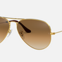 Ray-Ban RB3025 001/51 unisex's full rim aviator sunglasses in a gold metal frame with light brown lenses. Features a 62 mm lens size, 14 mm bridge size, and 135 mm temple length. Available in Dubai, UAE.