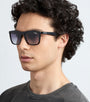 Man wearing black Carrera 5041/S 807 sunglasses and a dark grey shirt against a light grey background facing left side