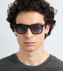 Model wearing black Carrera 5041/S 807 sunglasses and a dark grey shirt against a light grey background facing left front