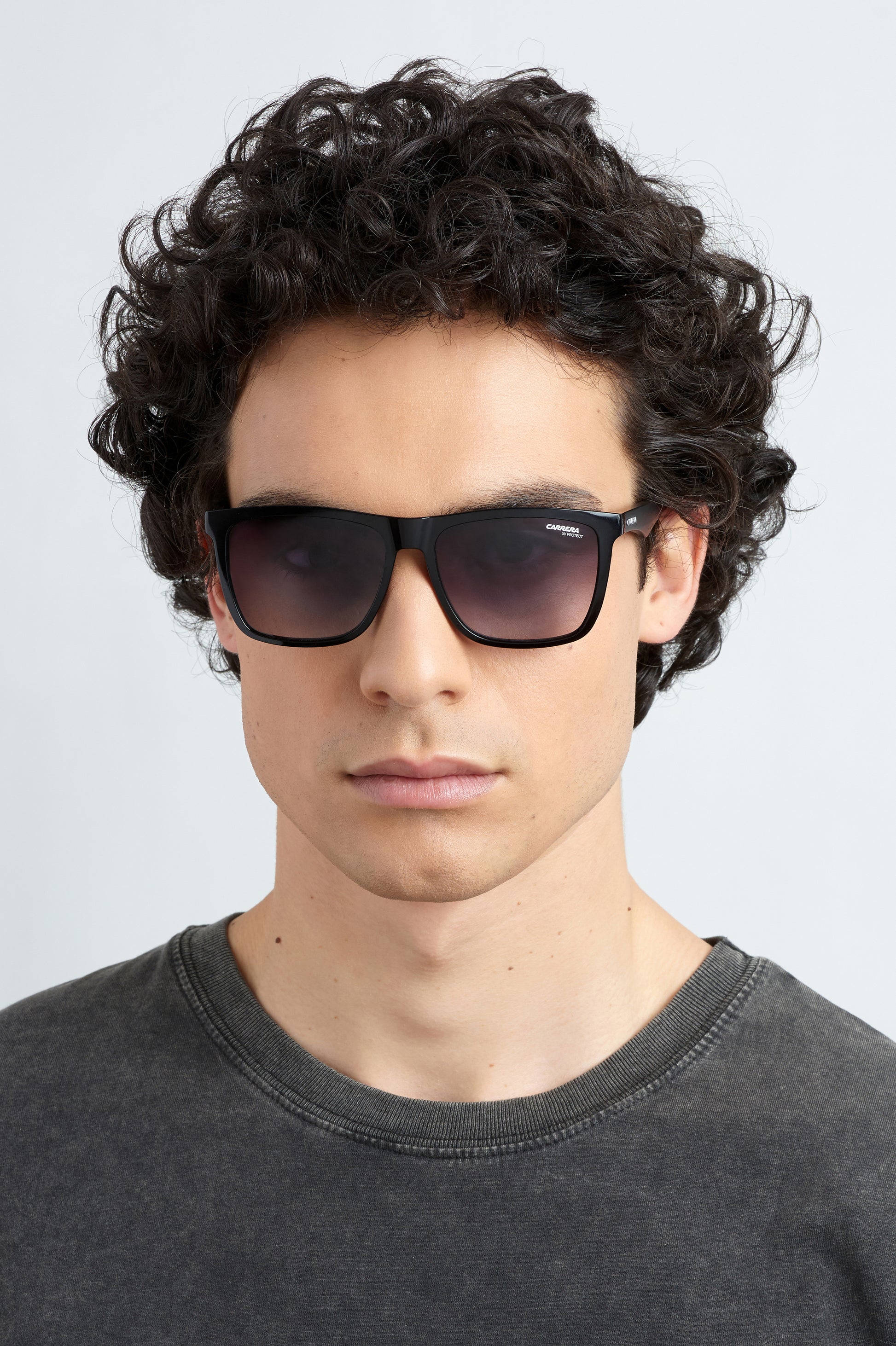 Model wearing black Carrera 5041/S 807 sunglasses and a dark grey shirt against a light grey background facing left front