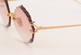 Eyepetizer Guadalupe C.4-61 irregular sunglasses for women in rimless steel, with gold frame, and orange gradient lenses. 56mm in lens size, 16mm in bridge size, and 145mm in temple length.