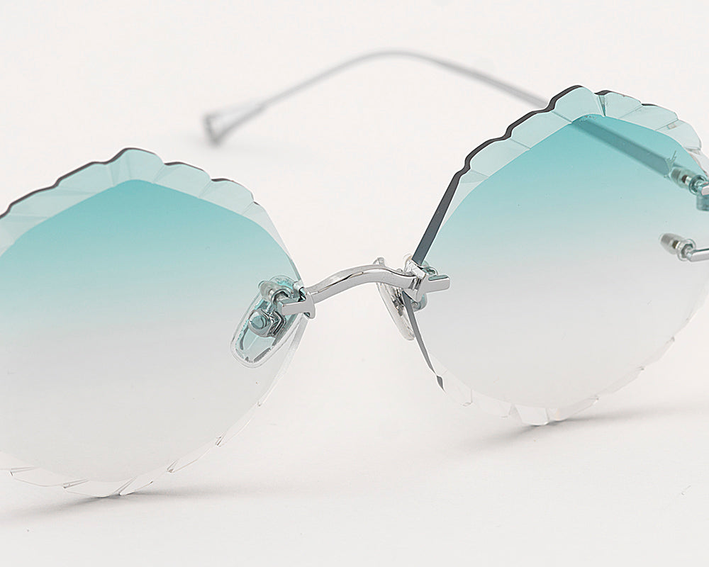 Eyepetizer Guadalupe C.1-59 irregular sunglasses for women in rimless steel, with silver frame, and gradient aqua green lenses. 56mm in lens size, 16mm in bridge size, and 145mm in temple length.