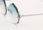 Eyepetizer Guadalupe C.1-59 irregular sunglasses for women in rimless steel, with silver frame, and gradient aqua green lenses. 56mm in lens size, 16mm in bridge size, and 145mm in temple length.
