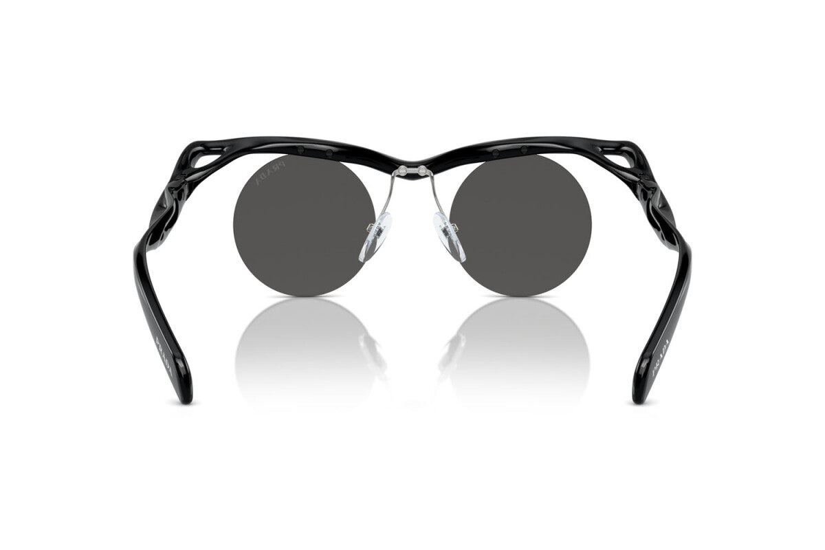 Prada PR A18S 1AB5S0 round sunglasses for men in rimless injected, with black frame, and dark grey lenses. 43mm in lens size, 22mm in bridge size, and 135mm in temple length.