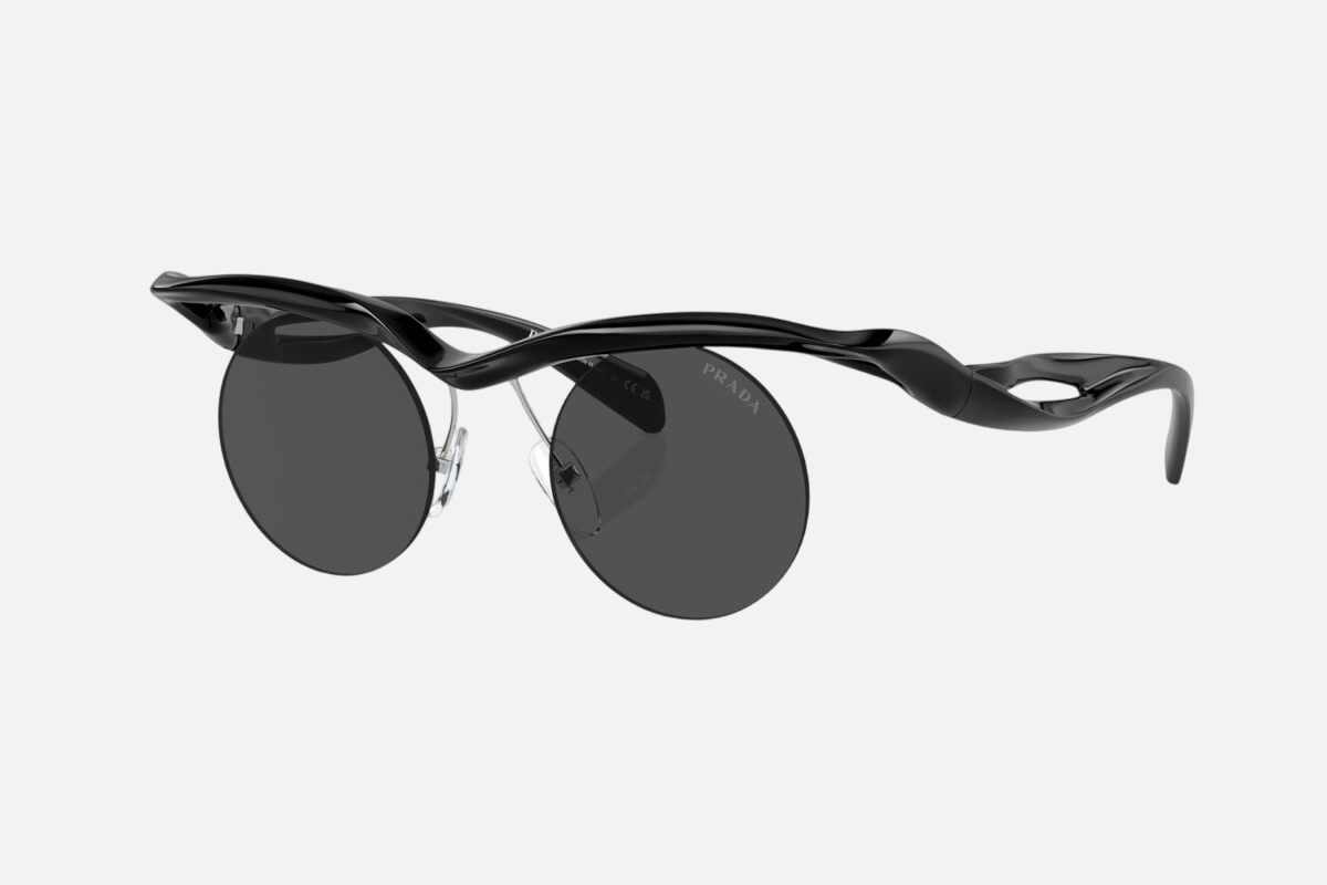 Prada PR A18S 1AB5S0 round sunglasses for men in rimless injected, with black frame, and dark grey lenses. 43mm in lens size, 22mm in bridge size, and 135mm in temple length.